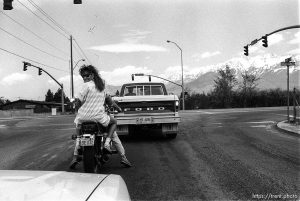 Girl on motorcycle looks back.