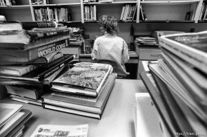 Librarian surrounded by returned books for a story on the Provo Library being overcrowded.