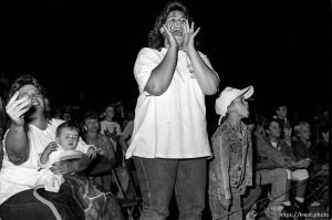 Women in crowd try to tell babyface wrestler that the heel wrestler has an illegal object at professional wrestling match. 