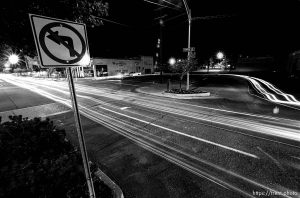 Cars U-turn to cruise on Center Street at night.