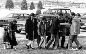 Family carries casket at funeral of School superintendant (Moss).