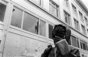 Woman covers her face as she walks by