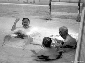 Newell Knight gets a friendly spray from a lifeguard as buddies ____ and ____ laugh.  