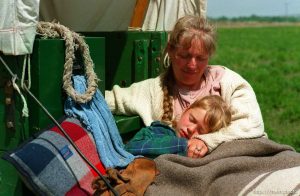 Sarah Dicken in the arms of her mother Shauna on the Mormon Trail Wagon Train. Sarah has a fever of 102°. They are from Washington state, and have no support vehicles. Just the wagon.