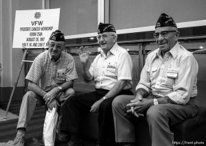 Three vets standing in front of a sign reading 