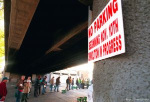 Homeless men wait in line for coffee just before the last Sunday morning breakfast served to the homeless by volunteers under the 400 South viaduct. The viaduct will be torn down as part of the massive freeway construction project.