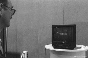 Men watching a video on nuclear attack (here showing 