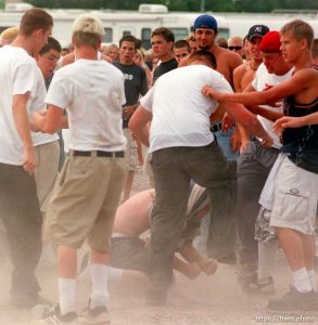 Violence breaks out at the Salt Lake City, Utah stop of the Vans Warped Tour as hardcore punks and straightedge kids stomp their victim. In the mid 90's after numerous violent incidents, the Salt Lake City Police Department formally declared straightedge a violent gang. July 10, 1999. photo copyright - Trent Nelson. http://www.trenthead.com