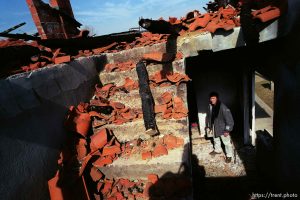 Naim Begiri in the ruins of his uncle's house, where he hid from Serb forces during the war.