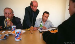 Gustin Benisha wolfs down a banana while Valdet Millaku and Ed Knowles discuss relief efforts. At right is Valdrine Morina.