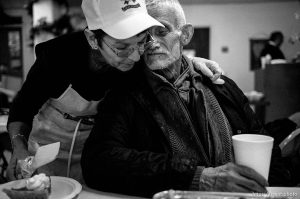 Volunteer Barbara Wilkinson gives Robert Carothers a hug Thanksgiving dinner at the Salt Lake City Mission.