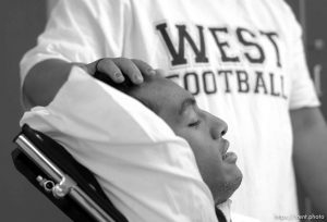 Una Taufa sits in a wheelchair while his sister Ola Taufa rubs his forehead. West High football player Una Taufa suffered a severe neck injury in a game two weeks ago and is partially paralyzed. He has begun the long and arduous rehabilitation process at LDS Hospital. . 09/27/2001, 11:33:50 AM
