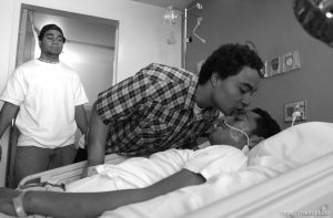 Steven Vaenuku, a teammate of Una Taufa's at West High School, kisses his forehead at the end of a visit to Taufu's hospital room. Man at left will be identified shortly. West High football player Una Taufa suffered a severe neck injury in a game two weeks ago and is partially paralyzed. He has begun the long and arduous rehabilitation process at LDS Hospital.. 09/27/2001, 12:15:58 PM