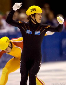 Japan's Takafumi Nishitani celebrates his first place in the 500 meter finals, Short Track Olympic Qualifier at the Delta Center Friday night. Behind him is 3rd place finisher, Canada's Eric Bedard. . 10/26/2001, 8:44:32 PM