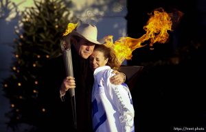 President George Bush consoles torch runner Elizabeth Howell after the two lit the Olympic Cauldron on the South Lawn of the White House Saturday morning. Howell, a native of Honeyville, Utah, lost her husband of five years, Brady Howell, in the attack on the Pentagon.
 12.22.2001, 6:28:27 AM