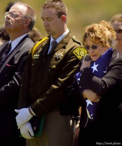 Family members (left to right: father Steve Thomas, brother Andy Thomas, and mother Carol Thomas Young) stand for the benediction prayer at the funeral for Brandon Thomas, a green beret killed in Iraq while working as a civilian security contractor. Thomas was buried at the Utah State Veterans Cemetery in Bluffdale. Photo by Trent Nelson; 5.24.2005