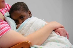A young child in the arms of volunteer Carolyn Clark in the daycare center (Camp BeBe) at Camp Williams, where people who were evacuated from the hurricane Katrina disaster in New Orleans, are making a go of it.