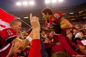Utah quarterback Brett Ratliff and Travis LaTendresse (right) are lifted up by fans after the win. University of Utah vs. Georgia Tech, Emerald Bowl, San Francisco.