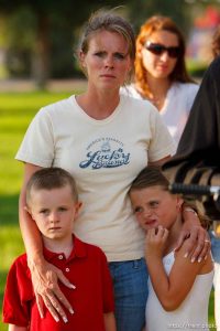 Huntington - Family members of miners missing in the Crandall Canyon coal mine stand with spokesman Sonny Olsen as he reads their statement to the media in the Huntington City Park. The family members wished to remain unidentified. ; 8.23.2007