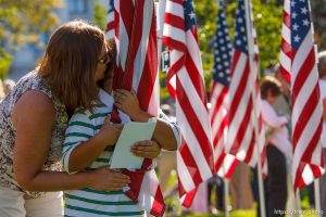 Terri Morris and her son Wyley Morris (8) embrace a flag memorializing Terri's uncle, Tooele county sheriff Sgt. Lauren Dow, who died in the line of duty in 1975. Salt Lake City - The new Utah Law Enforcement Memorial was dedicated Saturday, September 6, 2008 in a ceremony on the grounds of the Utah State Capitol.
