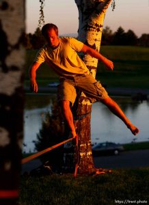Salt Lake City - Matt Pallach works on his balance slicklining between two trees in SugarHouse Park Friday, July 17, 2009.
Trent Nelson/The Salt Lake Tribune; 7.17.2009