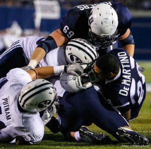 Trent Nelson  |  The Salt Lake Tribune BYU defensive lineman Matt Putnam (41) pulls off Joey DeMartino's helmet during the first half. Utah State vs. BYU college football in Logan Friday, October 1, 2010.