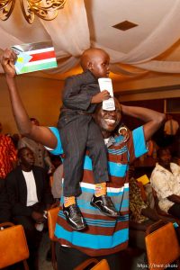 Trent Nelson  |  The Salt Lake Tribune Mamer Ngong holds up Alayou Aew during the national anthem at the South Sudan Independence celebration in Salt Lake City, Utah, Saturday, July 9, 2011