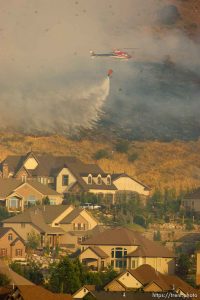 Trent Nelson  |  The Salt Lake Tribune Helicopter water drop. A smoky fire burns near homes in Draper, Utah, Saturday, August 13, 2011.
