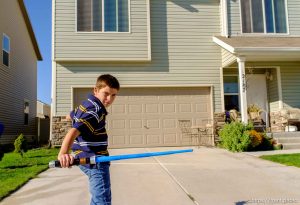 Trent Nelson  |  The Salt Lake Tribune Michael Chambers wields a lightsaber at the foster home where he lives in Eagle Mountain, Utah, Wednesday, September 12, 2012. Due to the lack of services for children with autism, a small number of families are turning their children, like Chambers, over to the child welfare system each year desperate for the services they can get in state custody.