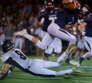 Trent Nelson  |  The Salt Lake Tribune Woods Cross's Braxton Gunther leaps over Corner Canyon's Jake Cahoon as Woods Cross hosts Corner Canyon High School football, in Woods Cross, Wednesday October 15, 2014.