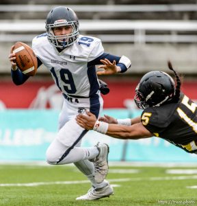 Trent Nelson  |  The Salt Lake Tribune Corner Canyon's Kyle Reaveley runs from Roy's Baby Eteuati Corner Canyon faces Roy High School in a  4A state football semifinal game at Rice-Eccles Stadium in Salt Lake City, Friday November 14, 2014.
