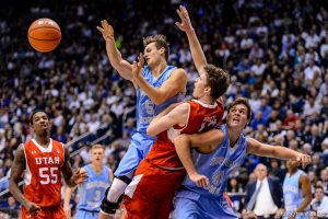 Trent Nelson  |  The Salt Lake Tribune Brigham Young Cougars guard Kyle Collinsworth (5) passes the ball after colliding with Utah Utes forward Jakob Poeltl (42) as BYU hosts Utah, college basketball at the Marriott Center in Provo, Wednesday December 10, 2014. At left is Utah Utes guard Delon Wright (55), at right Brigham Young Cougars forward Luke Worthington (41).