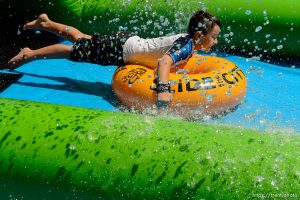 Trent Nelson  |  The Salt Lake Tribune
A rider slides down Main Street on a massive slip 'n slide put up by Slide the City, in Salt Lake City, Saturday August 22, 2015.