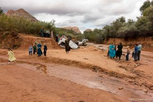 Trent Nelson  |  The Salt Lake Tribune People at the spot in a Hildale wash Tuesday September 15, 2015 where two vehicles ended up after being washed away in a flash flood. Nine people died (with four still missing) when the SUV and van were washed off a road during a flash flood in this polygamous Utah-Arizona border community.