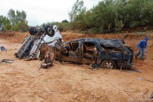 Trent Nelson  |  The Salt Lake Tribune People at the spot in a Hildale wash Tuesday September 15, 2015 where two vehicles ended up after being washed away in a flash flood. Nine people died (with four still missing) when the SUV and van were washed off a road during a flash flood in this polygamous Utah-Arizona border community.