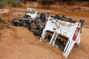 Trent Nelson  |  The Salt Lake Tribune People at the spot in a Hildale wash Tuesday September 15, 2015 where two vehicles ended up after being washed away in a flash flood. Nine people died (with four still missing) when the SUV and van were washed off a road during a flash flood in this polygamous Utah-Arizona border community.