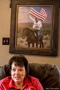 Trent Nelson  |  The Salt Lake Tribune Carol Bundy in the front room of the family's ranch home in Bunkerville, NV, Thursday April 14, 2016. A painting of her husband, Cliven Bundy, holding an American flag on horseback, hangs behind her.