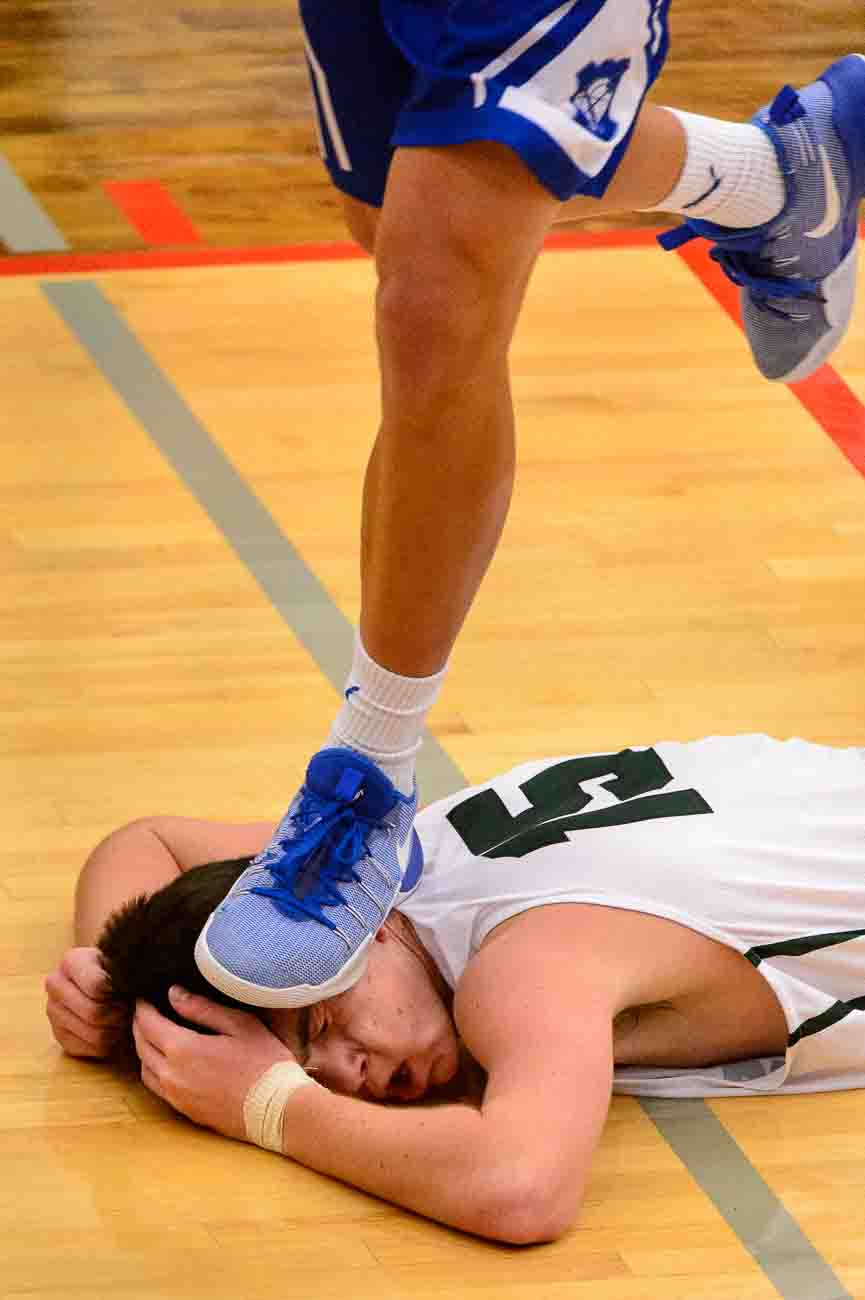 (Trent Nelson | The Salt Lake Tribune)  A Bingham player inadvertently steps on the head of Olympus's Rylan Jones as Olympus faces Bingham, high school boys' basketball at the Utah Elite 8 tournament in American Fork, Thursday December 7, 2017.