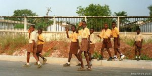 School boys wave as they walk.