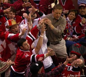 Fans grab for a flying hockey puck. First period. Czech Republic vs. Canada, Mens Hockey, Monday afternoon at the E Center, 2002 Olympic Winter Games.; 02.18.2002, 6:01:45 PM