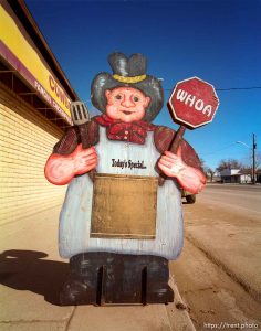 Cowboy cutout in front of roadside cafe.