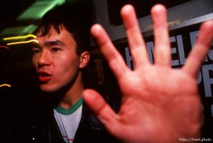 Guy covering my lens while his friends spray paint a bus during Anti-war Gulf War protests.