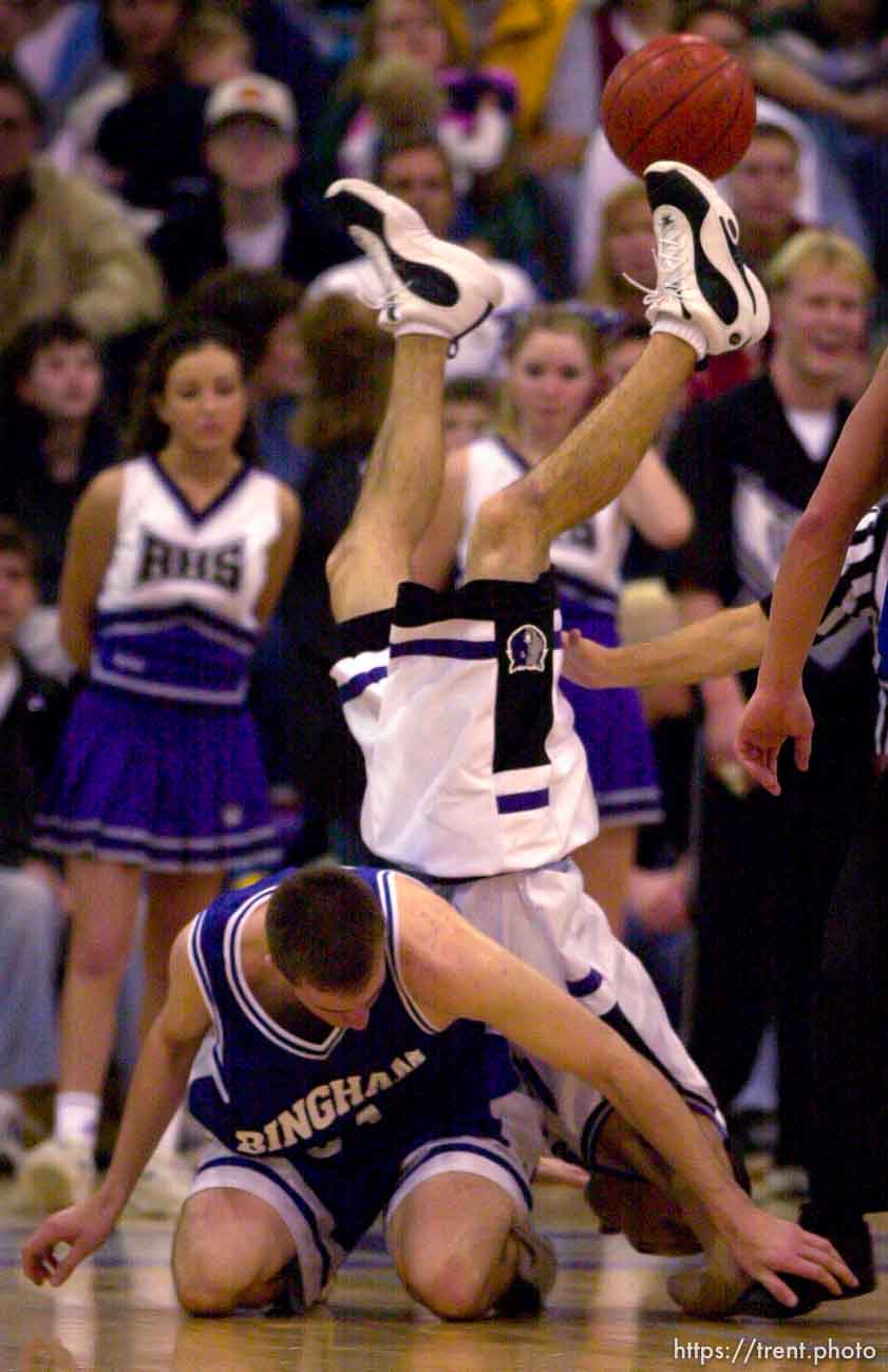 Riverton's Andrew Nuttall is upended going after the ball and over Bingham's Mike Higgins during Friday night's matchup. Bingham defeats Riverton, basketball.