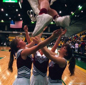 North Sevier cheerleaders (left to right) Ashley Burr, Jennifer Brown, and Ashlee McKinlay prepare to catch Laura Leaming (top) during a game in the state championship basketball tournament.