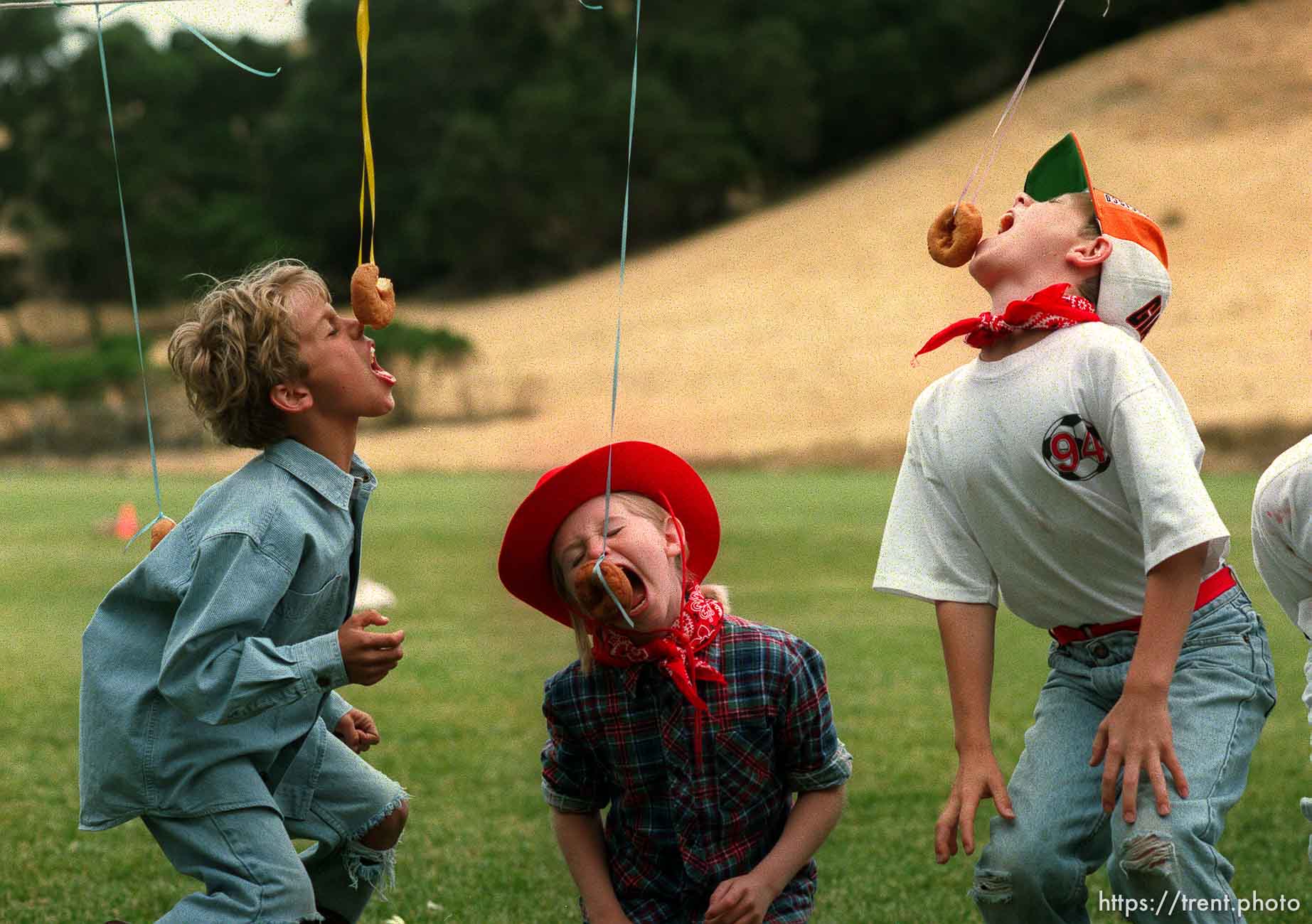 Kids eating donuts on strings