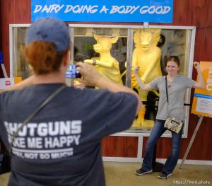 i(Trent Nelson | The Salt Lake Tribune)   Lauren Pearce poses for her mother Katrina in front of the Utah Butter Cow Sculpture at the Utah State Fair, Sunday Sept. 9, 2018.