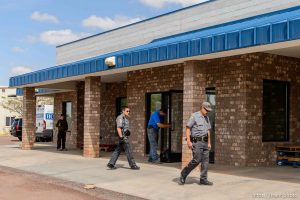 Trent Nelson  |  The Salt Lake Tribune Mohave County Sheriff deputies on the grounds of what had been the FLDS food storehouse in Colorado City, AZ, as locksmith Kelvin Holdaway changes the locks during an eviction, Monday May 8, 2017.