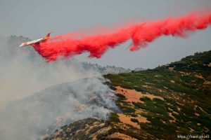 (Trent Nelson | The Salt Lake Tribune)  A plane makes a drop on a fire at the mouth of Weber Canyon, Tuesday September 5, 2017.