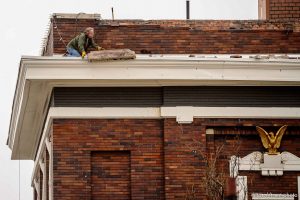 (Trent Nelson  |  The Salt Lake Tribune) Curt Green works to remove loose brick from the roof of Caffé Molise, damaged in an earthquake in Salt Lake City on Wednesday, March 18, 2020.