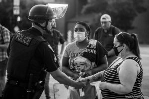 (Trent Nelson  |  The Salt Lake Tribune) A police officer shakes hands with protesters marching in Salt Lake City on Tuesday, June 2, 2020.